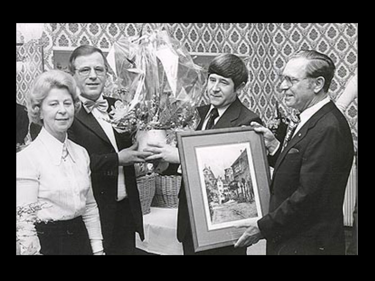 Feier zum 104-jährigen Jubiläum des Malerbetriebs in Heidelberg, Team mit Blumen und Gemälde.