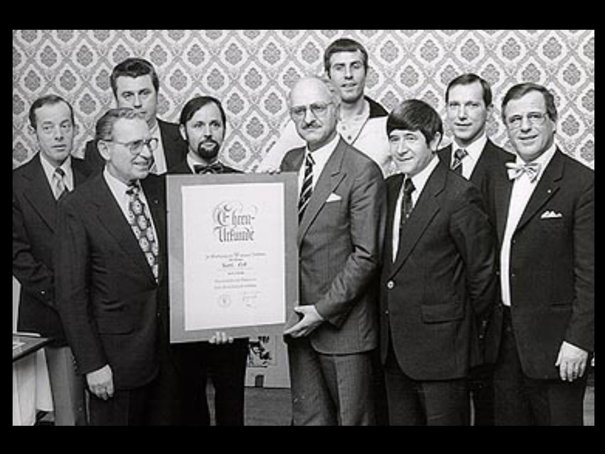 Ehrung für 104 Jahre Maler Eck in Heidelberg, Team mit Urkunde, Malermeister in Anzügen.