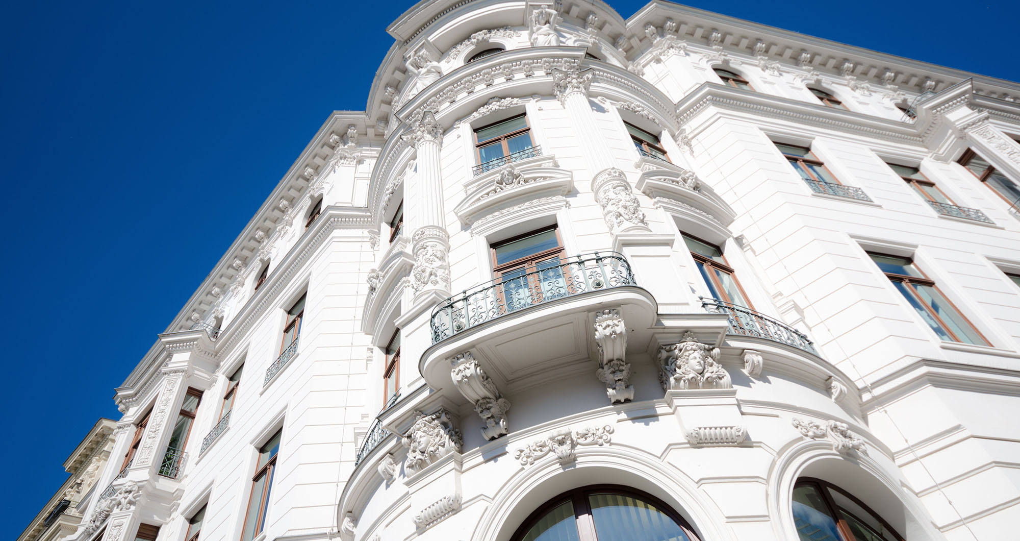 Altbaufassade in Heidelberg, renoviert von Maler Eck, zeigt kunstvolle Stuckarbeiten und frische weiße Farbe.