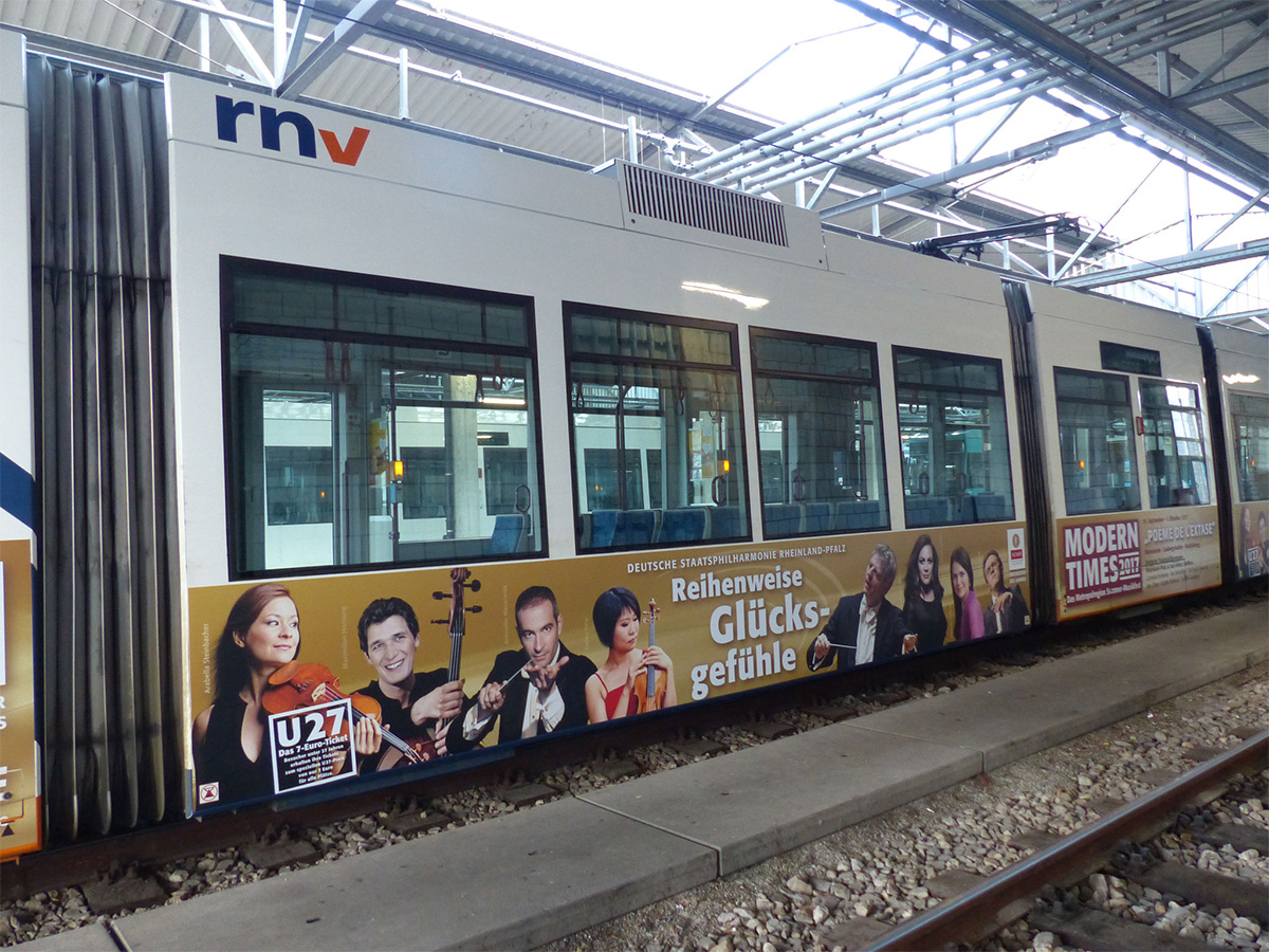 Eine Straßenbahn vom RNV mit Werbung für die Philharmonie Rheinland-Pfalz , beklebt von Malerbetrieb Malereck aus Heidelberg