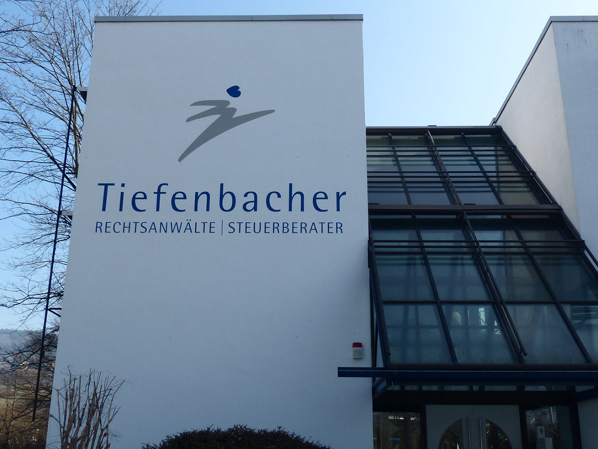 Fassade eines Gebäudes mit dem Logo der Tiefenbacher Rechtsanwälte und Steuerberater in Heidelberg.