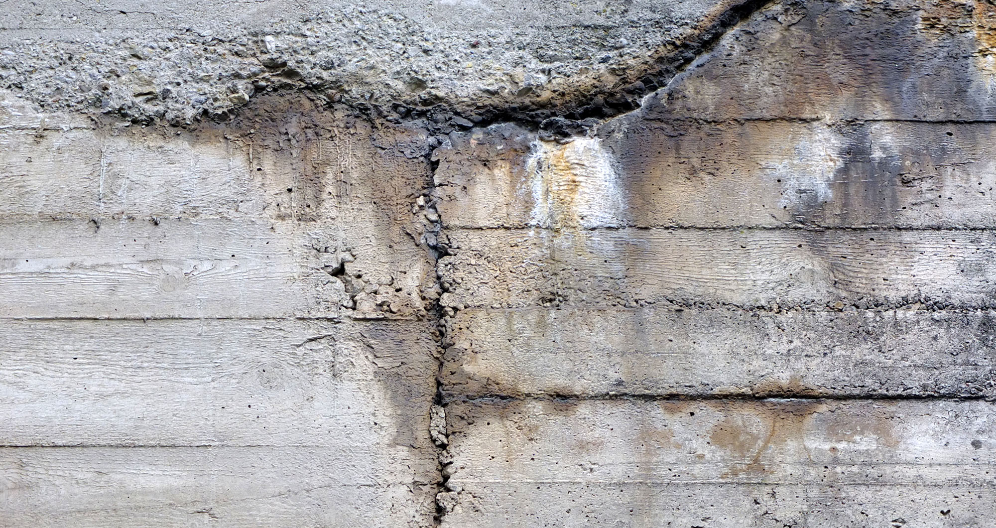 Betonsanierung durch Maler Eck in Heidelberg, zeigt beschädigte Betonwand vor der Sanierung.