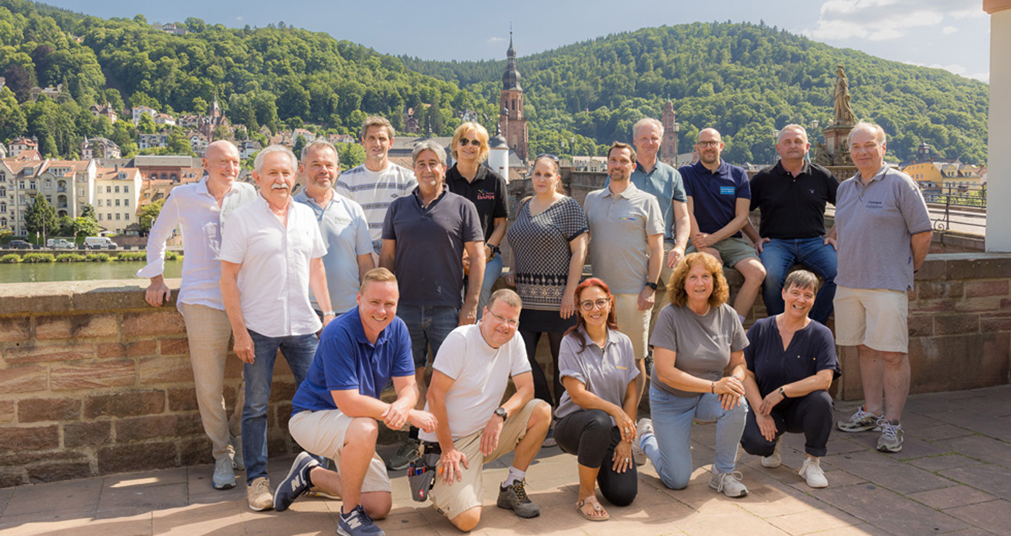 Gruppe von Malermeistern in Heidelberg vor historischer Kulisse.