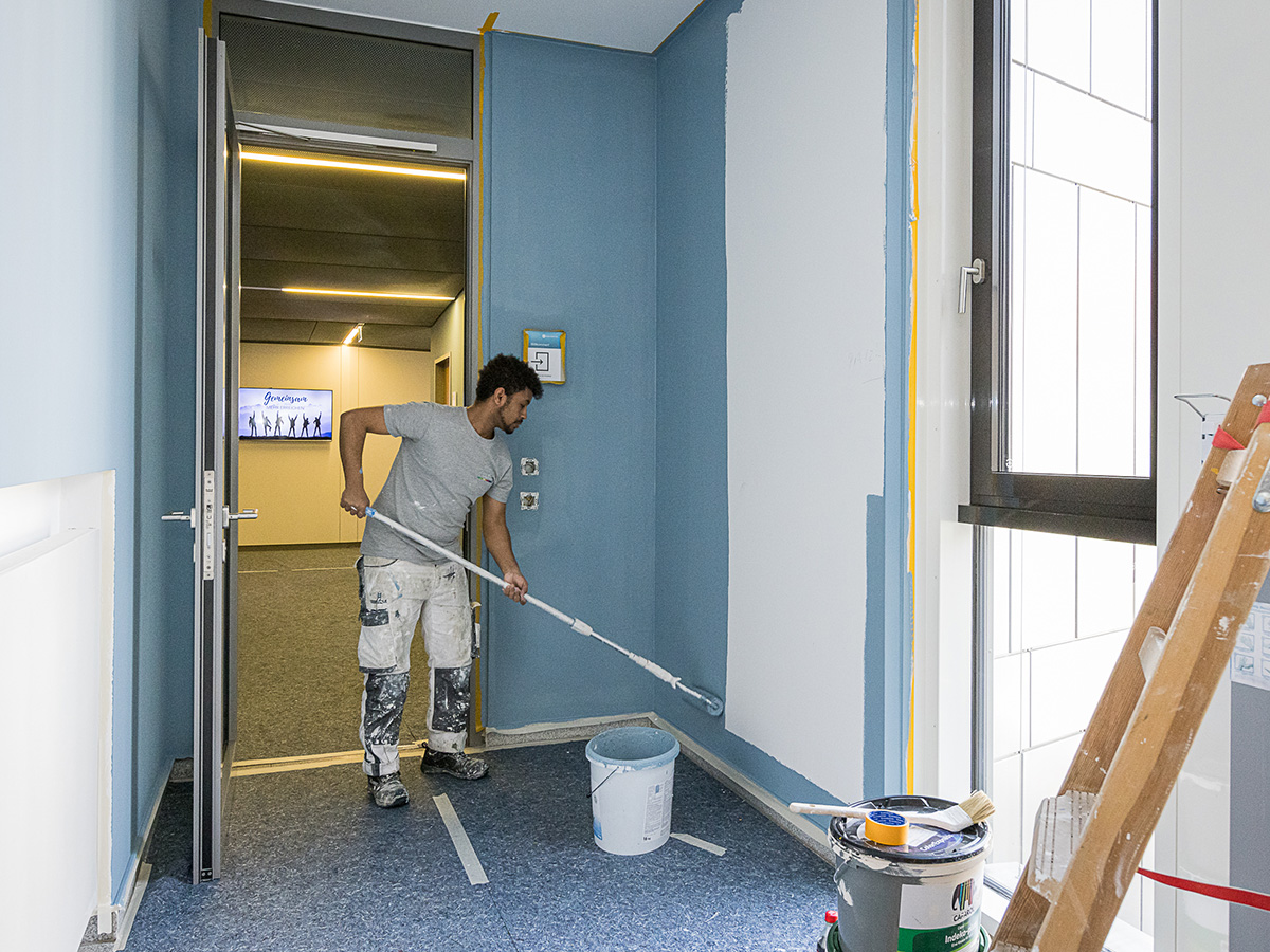 Malermeister bei der Wandgestaltung in Heidelberg, Maler Eck, mit blauer Farbe und professionellem Equipment.