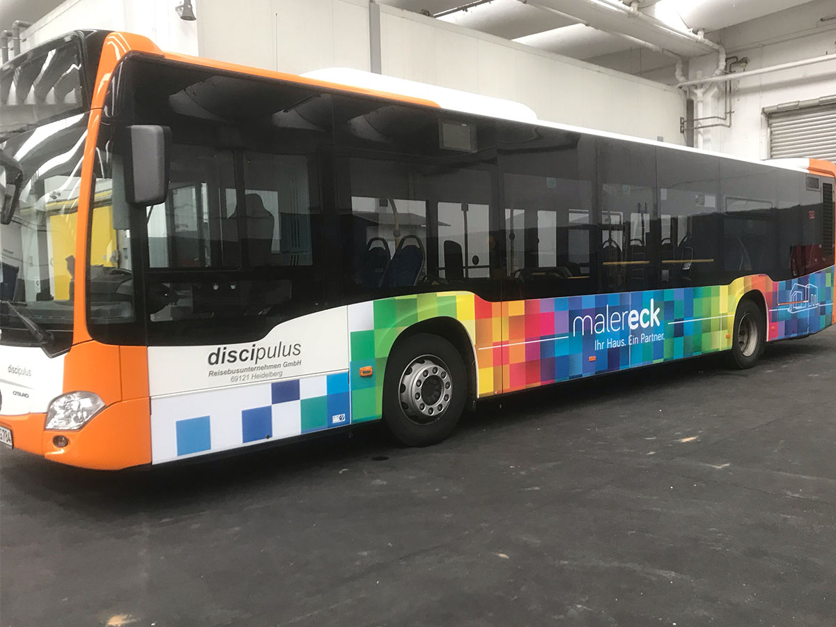 Bus mit bunter Maler Eck Werbung in Heidelberg Werkstatt.