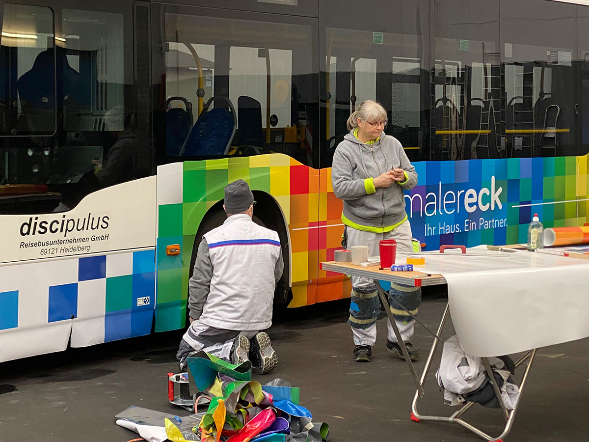 Malermeister bei der Beklebung eines Busses in Heidelberg.